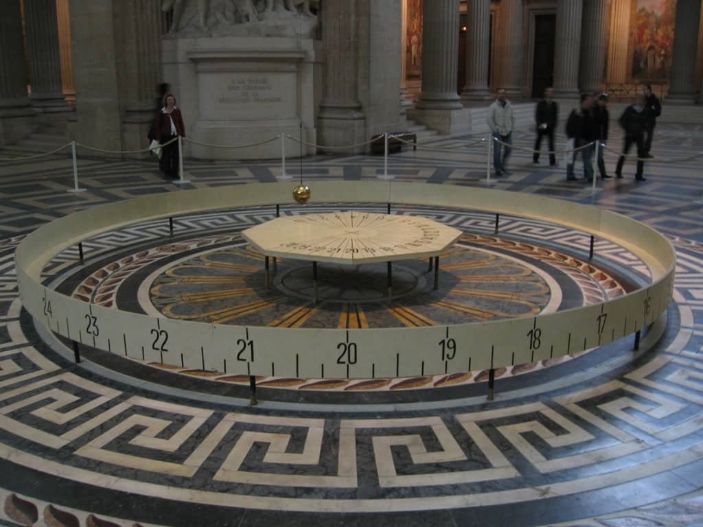 Un pendolo di Foucault installato in un edificio pubblico con la sfera metallica appesa a un lungo cavo
